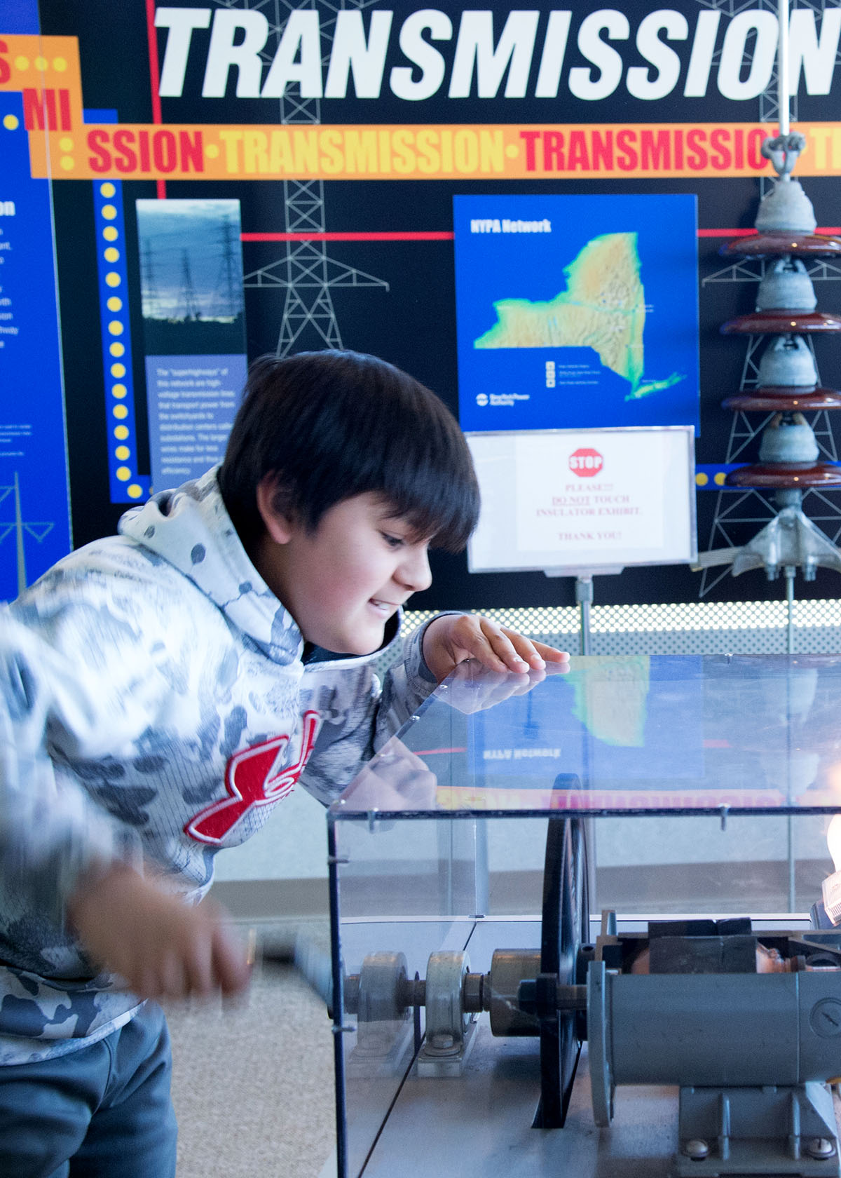 A boy hand-cranks a generator