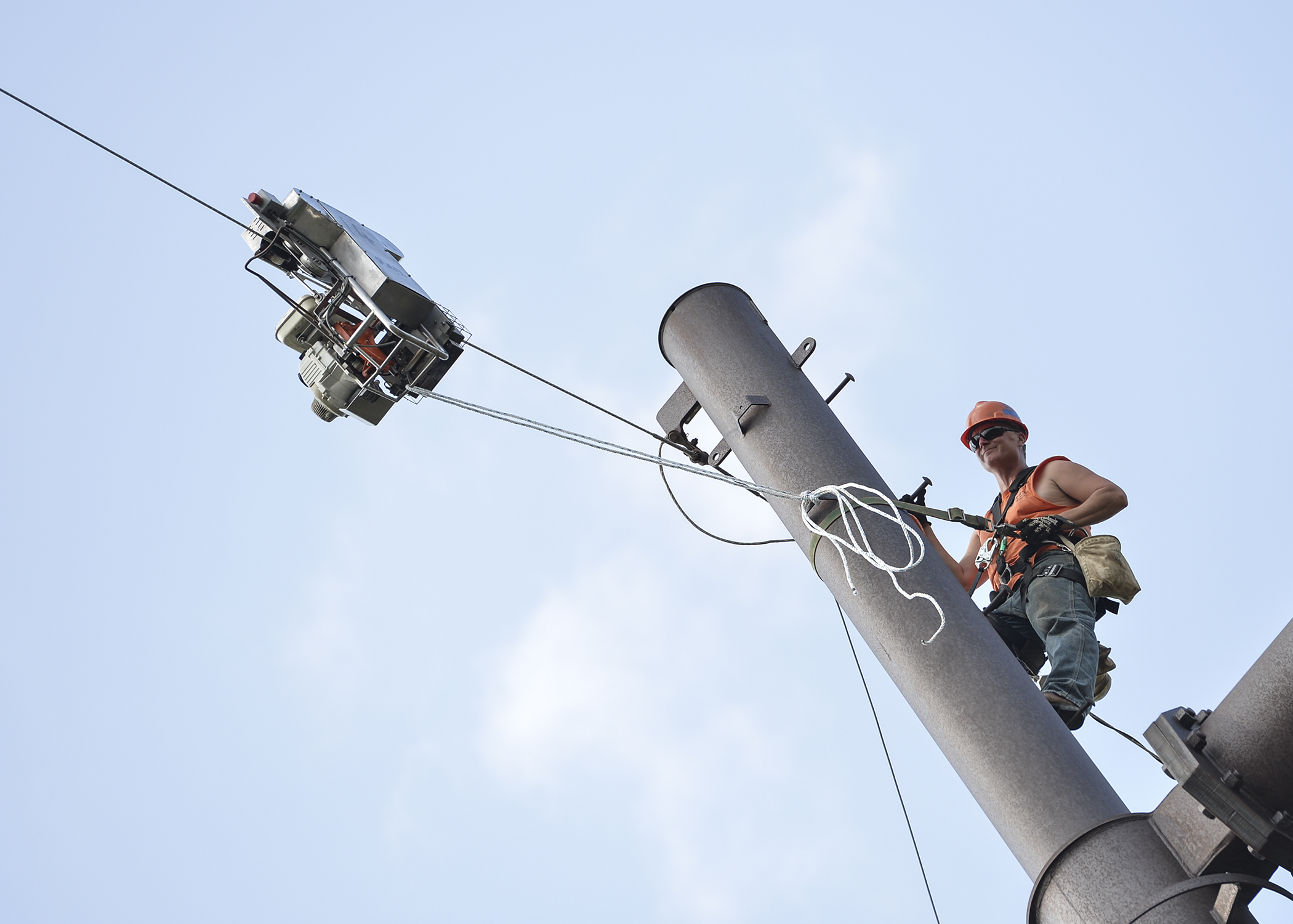 Line worker adds a fiber optic line to an existing cable.